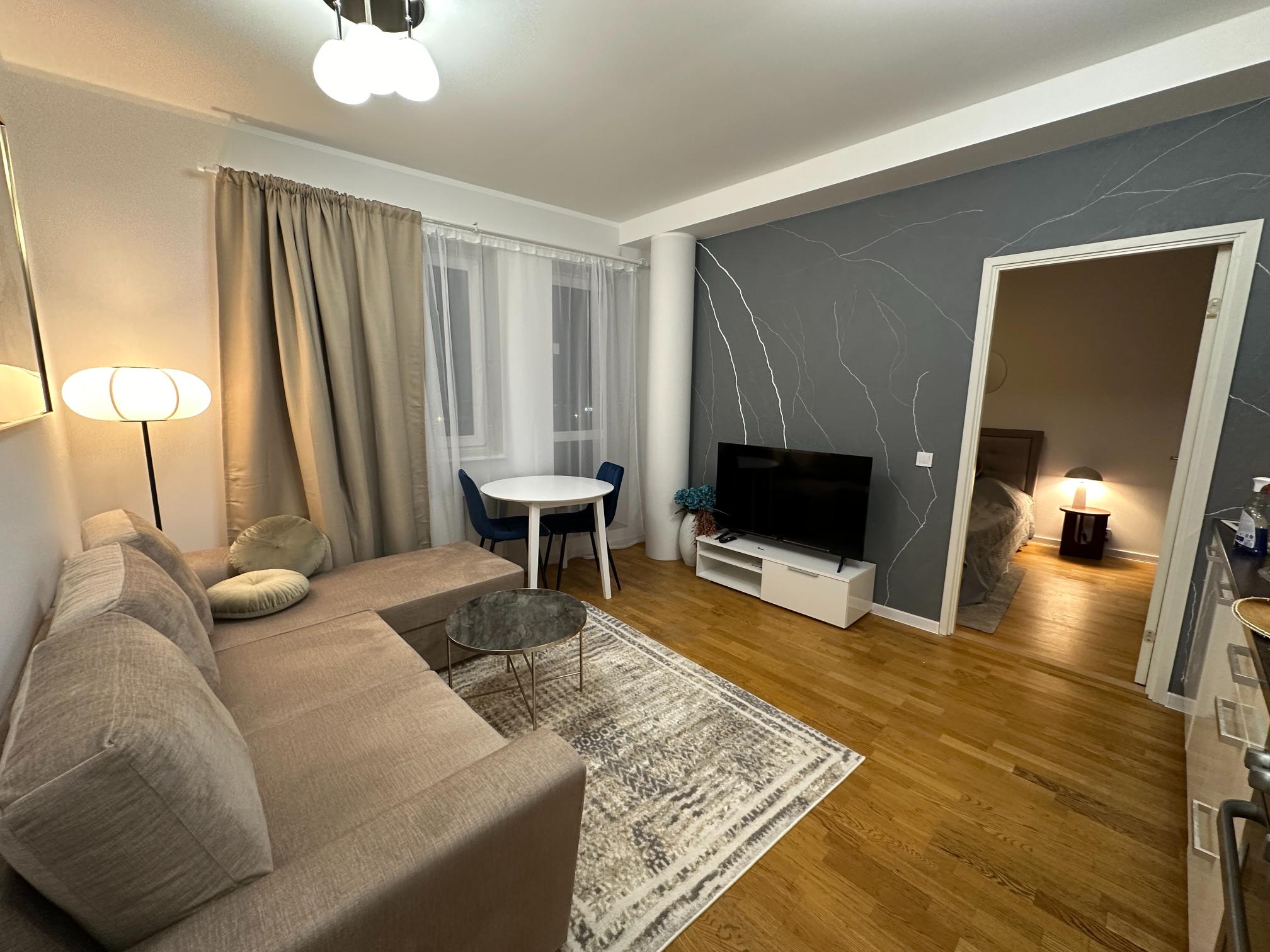 Stiilne ja avar elutuba koos nurgadiivani, söögilaua ja TV nurgaga.