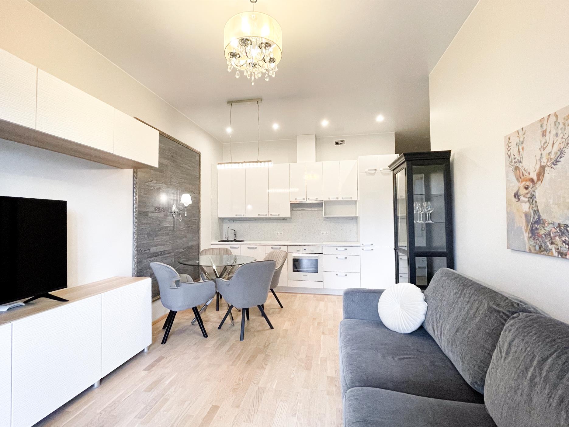 Hubane korter Realtoni Ida-Virumaa portfellist. Avatud köögiga elutuba, hall diivan ja modernne sisustus.