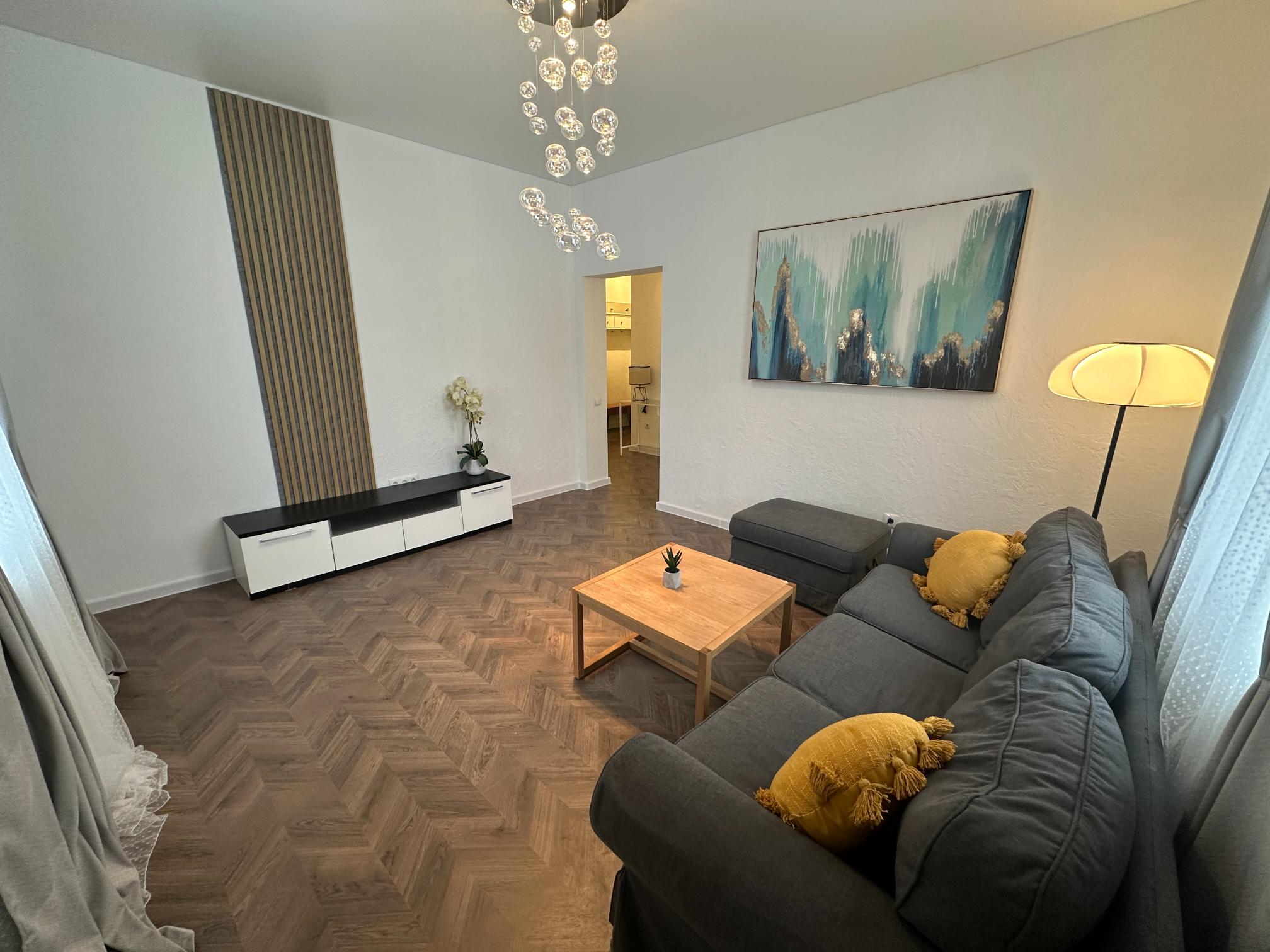 Moodne elutuba - hall diivan, kollased padjad ja kunstiteosega.